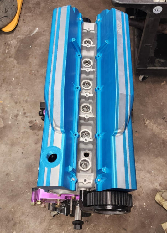 Blue billet rocker covers for RB engines, featuring integrated oil control technology and a precision-machined GT stripe.