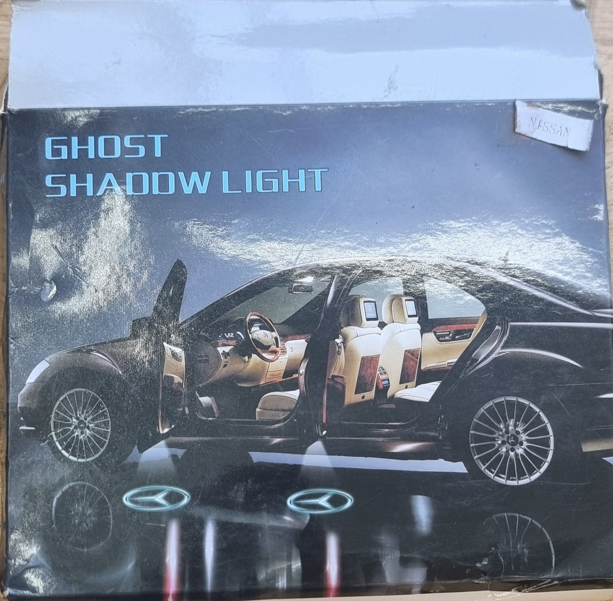 Box packaging for Nissan Ghost Shadow Lights featuring an image of a Nissan vehicle with the product enabled, projecting the Nissan logo on the ground.