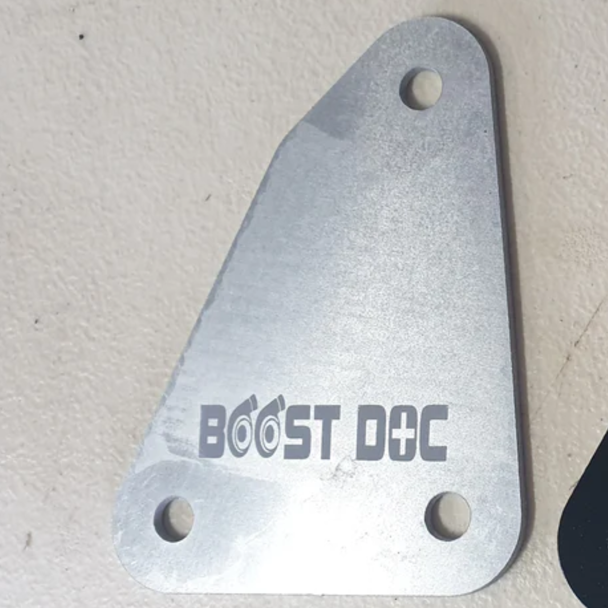 A raw aluminum finish speedo blancing plate for R32 Skyline with the text 'BOOST DOC' engraved on it R32 Speedo Firewall Blank skyline oem nissan parts gtr stagea safero r32 r33 r34 rb neo rb25 rb26 rb30