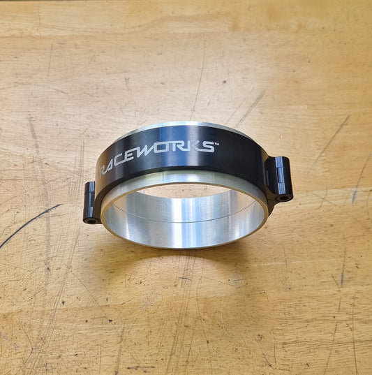 A black and silver 4 inch Raceworks intercooler clamp on a wooden surface.